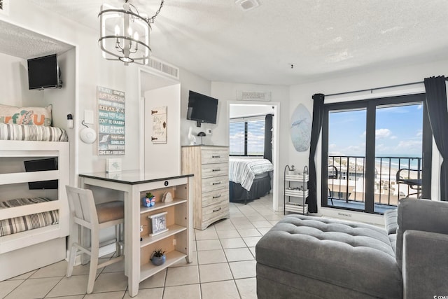 bedroom with a textured ceiling, access to exterior, light tile patterned flooring, and visible vents