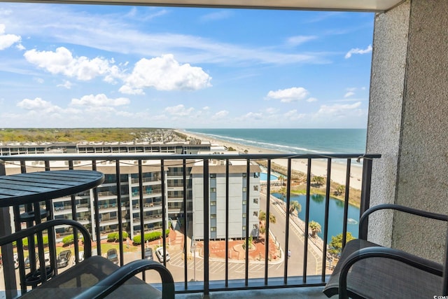 balcony with a water view and a view of the beach