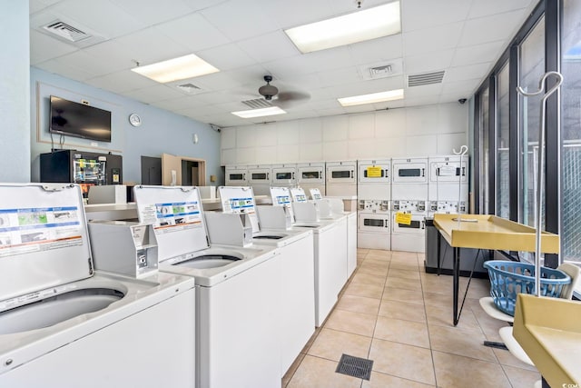 common laundry area featuring light tile patterned floors, ceiling fan, visible vents, and washing machine and clothes dryer