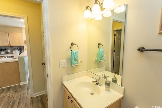 201 Landing Rd Unit D, North Myrtle Beach, SC 29582 - bathroom featuring vanity, an inviting chandelier, wood finished floors, and decorative backsplash
