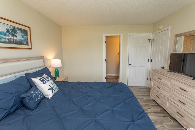 201 Landing Rd Unit D, North Myrtle Beach, SC 29582 - bedroom with dark wood finished floors and a textured ceiling