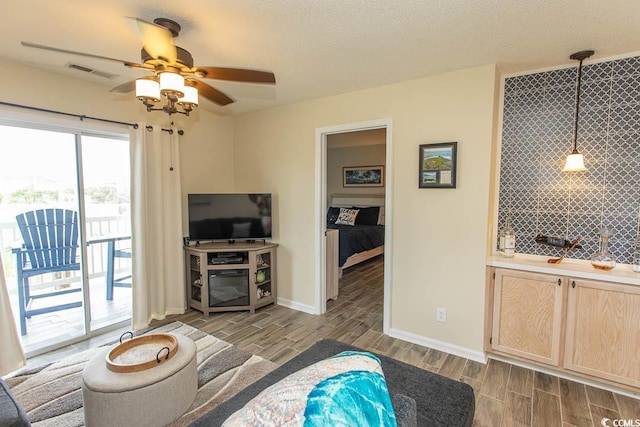 201 Landing Rd Unit D, North Myrtle Beach, SC 29582 - living room featuring indoor wet bar, wood tiled floor, a ceiling fan, visible vents, and baseboards