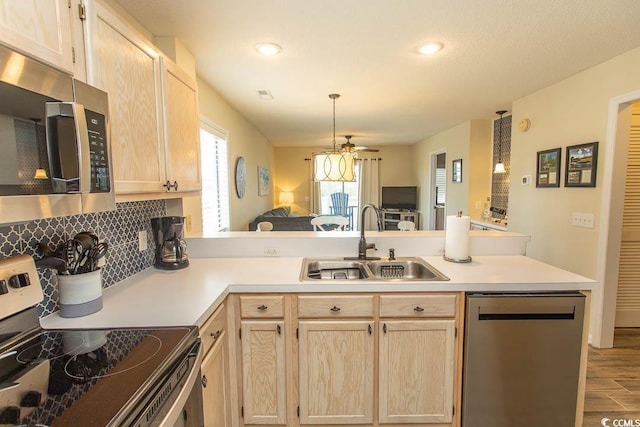 201 Landing Rd Unit D, North Myrtle Beach, SC 29582 - kitchen featuring a peninsula, light brown cabinetry, a sink, light countertops, and appliances with stainless steel finishes