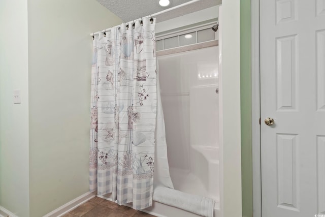 bathroom featuring baseboards, a textured ceiling, and a shower with curtain