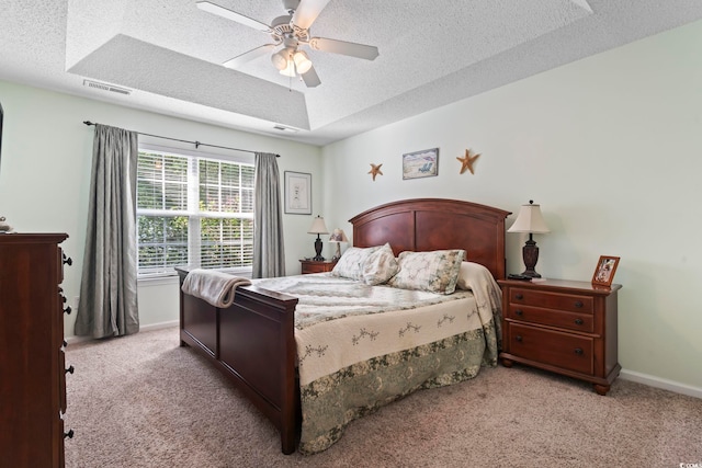 bedroom with carpet floors, a textured ceiling, visible vents, and baseboards