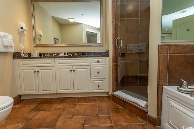 bathroom with vanity, stone finish flooring, visible vents, and a shower stall