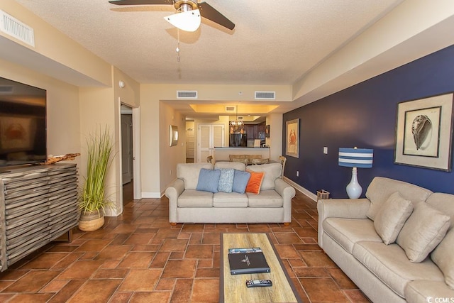 living area with a ceiling fan, baseboards, and visible vents