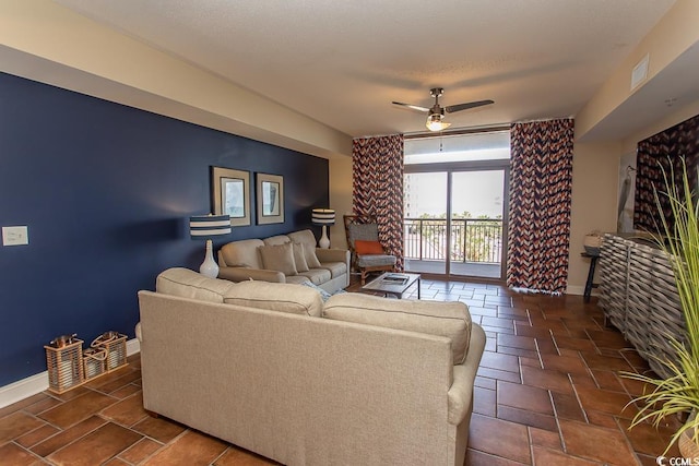 living area with baseboards, a ceiling fan, and visible vents