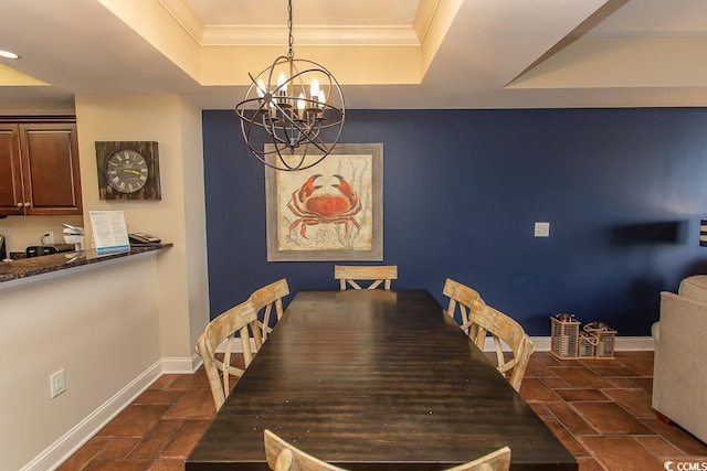 dining space featuring crown molding, stone tile floors, baseboards, a raised ceiling, and a chandelier