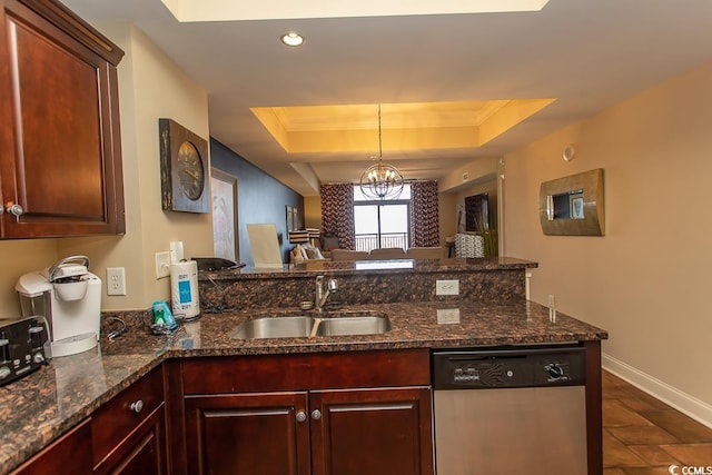 kitchen with a sink, dishwasher, a peninsula, baseboards, and a tray ceiling