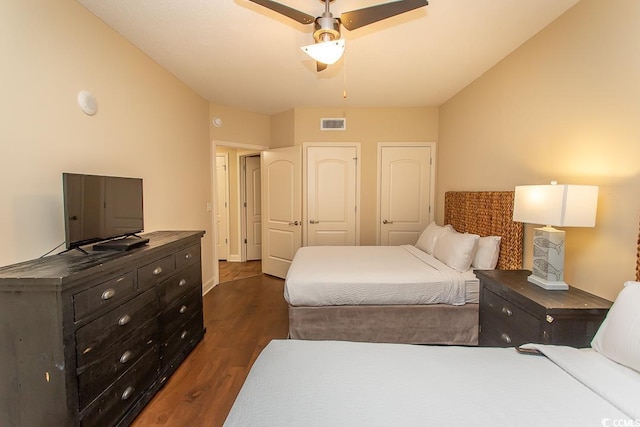 bedroom with a ceiling fan, dark wood-style flooring, and visible vents