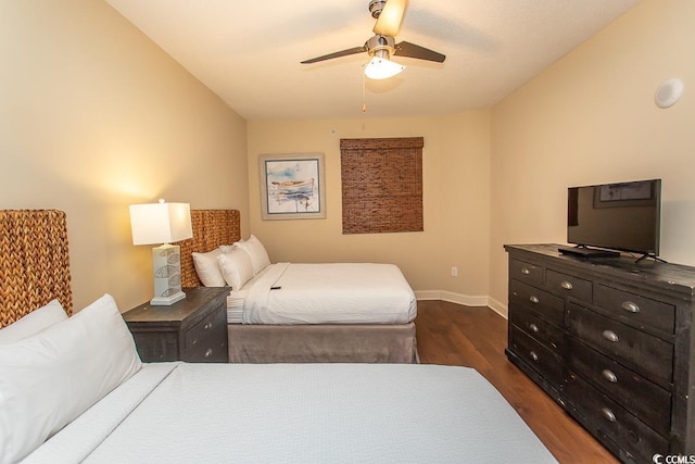 bedroom with a ceiling fan, baseboards, and dark wood-type flooring