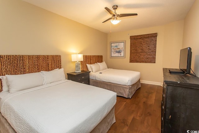 bedroom featuring baseboards, dark wood finished floors, and ceiling fan
