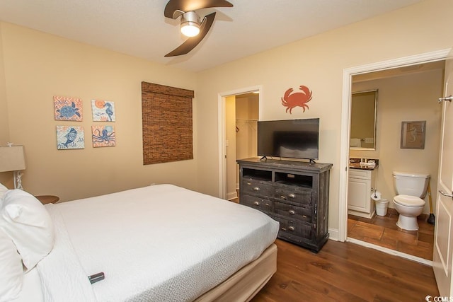 bedroom with a walk in closet, ceiling fan, dark wood-style floors, and ensuite bathroom