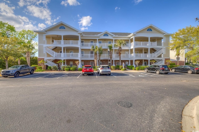 view of property with uncovered parking and stairway