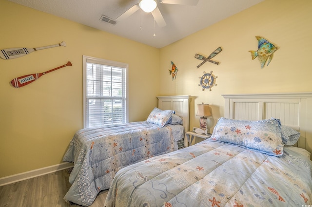 bedroom featuring baseboards, visible vents, wood finished floors, and ceiling fan