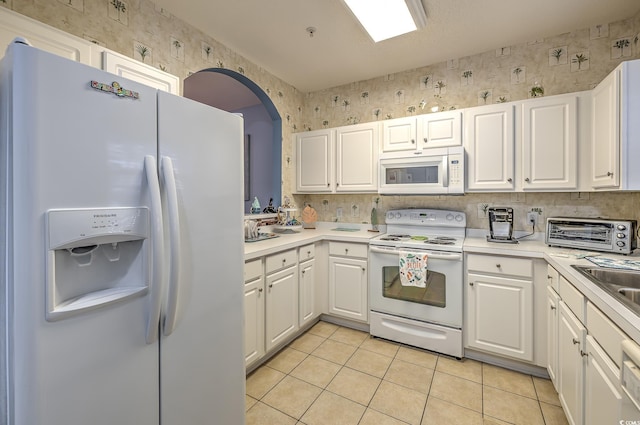 kitchen with light tile patterned floors, white cabinetry, wallpapered walls, a toaster, and white appliances