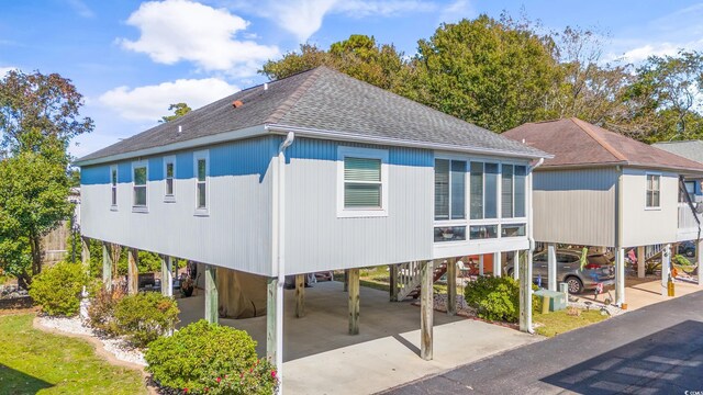 820 9th Ave S, North Myrtle Beach, SC 29582 - back of property featuring a carport, a shingled roof, and stairway