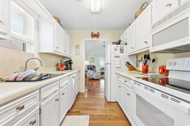 820 9th Ave S, North Myrtle Beach, SC 29582 - kitchen featuring white appliances, light wood-style floors, white cabinets, light countertops, and a ceiling fan