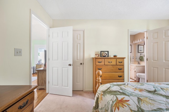 820 9th Ave S, North Myrtle Beach, SC 29582 - bedroom with ensuite bathroom, a textured ceiling, baseboards, and light colored carpet