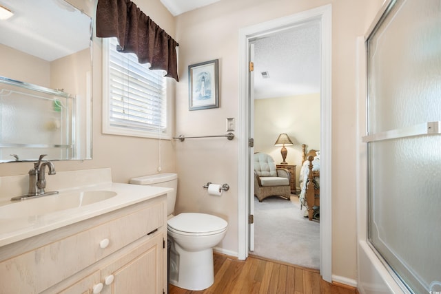 820 9th Ave S, North Myrtle Beach, SC 29582 - ensuite bathroom featuring wood finished floors, vanity, toilet, bath / shower combo with glass door, and baseboards