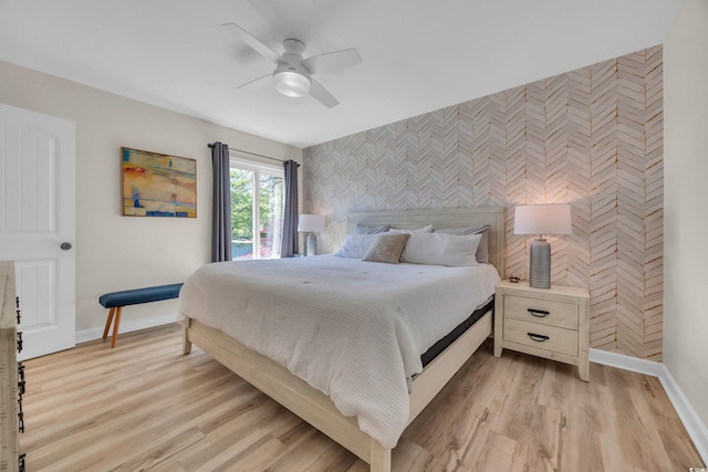 800 9th Ave S Unit A-4, North Myrtle Beach, SC 29582 - bedroom with light wood-style flooring, an accent wall, a ceiling fan, baseboards, and wallpapered walls