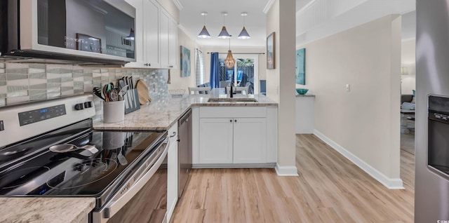 800 9th Ave S Unit A-4, North Myrtle Beach, SC 29582 - kitchen featuring appliances with stainless steel finishes, a sink, light wood finished floors, decorative backsplash, and white cabinetry