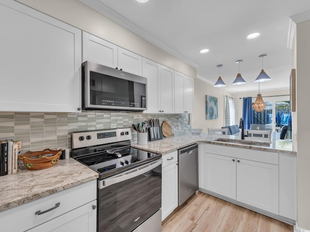 800 9th Ave S Unit A-4, North Myrtle Beach, SC 29582 - kitchen featuring ornamental molding, white cabinets, a sink, appliances with stainless steel finishes, and backsplash