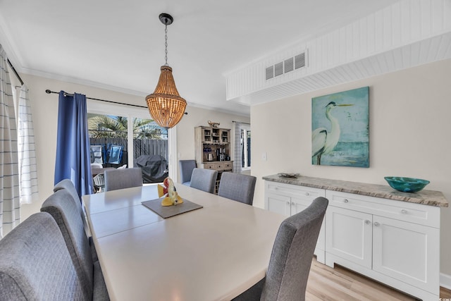 800 9th Ave S Unit A-4, North Myrtle Beach, SC 29582 - dining area featuring a chandelier, light wood-type flooring, and ornamental molding