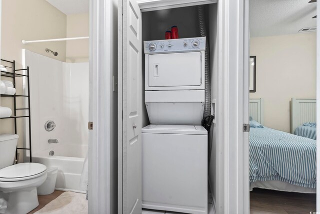 102 Scotch Broom Dr Unit B-302, Little River, SC 29566 - bathroom featuring stacked washer and clothes dryer, ensuite bath, toilet, visible vents, and wood finished floors