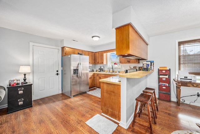 706 Birch Ln, Conway, SC 29526 - kitchen featuring brown cabinetry, dark wood finished floors, stainless steel fridge with ice dispenser, a peninsula, and light countertops