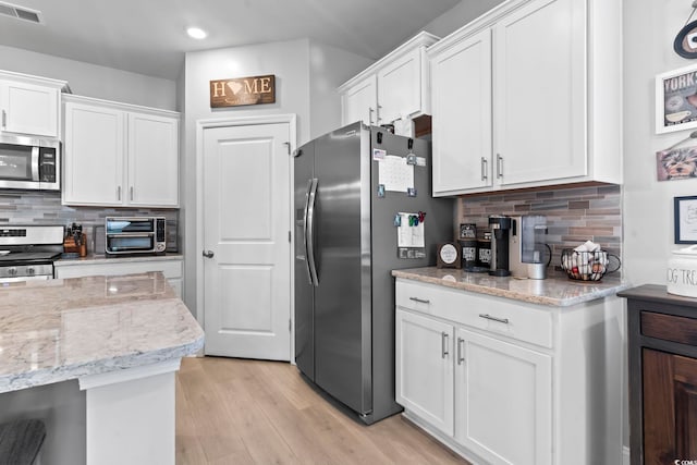 239 Calhoun Falls Dr, Myrtle Beach, SC 29579 - kitchen featuring appliances with stainless steel finishes, white cabinets, recessed lighting, decorative backsplash, and light wood-style flooring