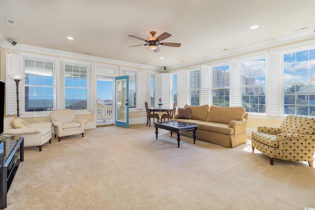 living area featuring ornamental molding, light carpet, ceiling fan, and visible vents