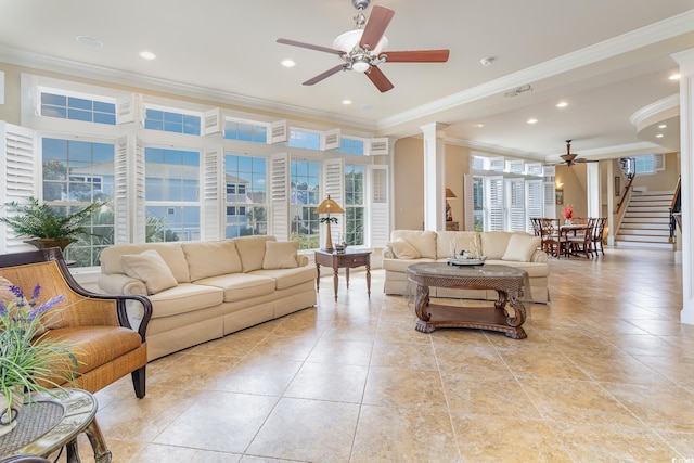 living room with crown molding, decorative columns, stairway, and a ceiling fan