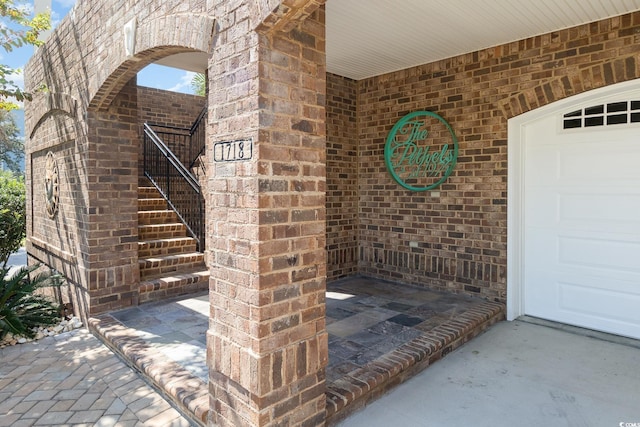property entrance featuring brick siding and a garage