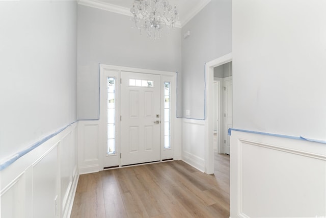 1500 Sunmeadow Dr, Conway, SC 29526 - entrance foyer featuring light wood-type flooring, a chandelier, ornamental molding, wainscoting, and a decorative wall