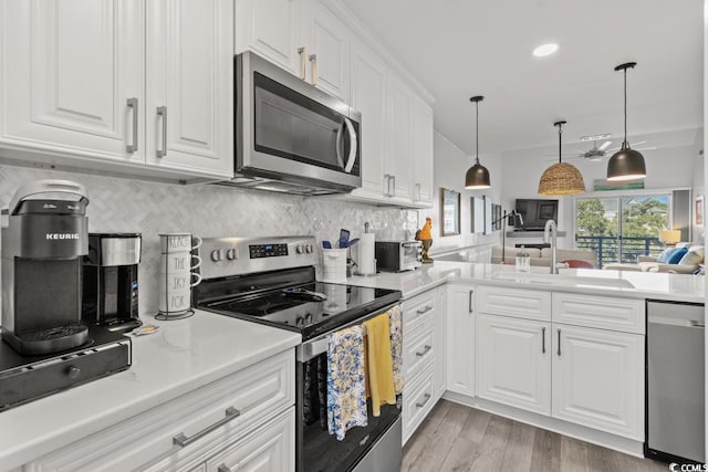 201 N Hillside Dr N Unit 307, North Myrtle Beach, SC 29582 - kitchen featuring backsplash, appliances with stainless steel finishes, a sink, and white cabinetry