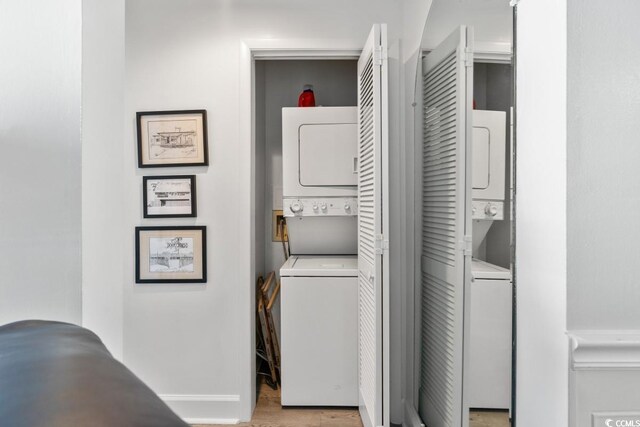 201 N Hillside Dr N Unit 307, North Myrtle Beach, SC 29582 - clothes washing area featuring stacked washer and dryer, baseboards, light wood-style floors, and laundry area