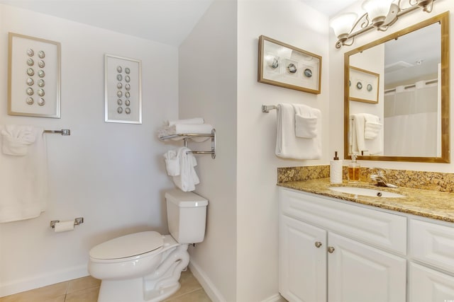 bathroom with toilet, baseboards, tile patterned flooring, and vanity