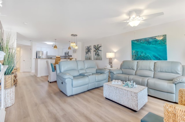 living area featuring light wood-style floors and ceiling fan