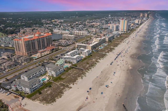 birds eye view of property with a water view, a city view, and a beach view
