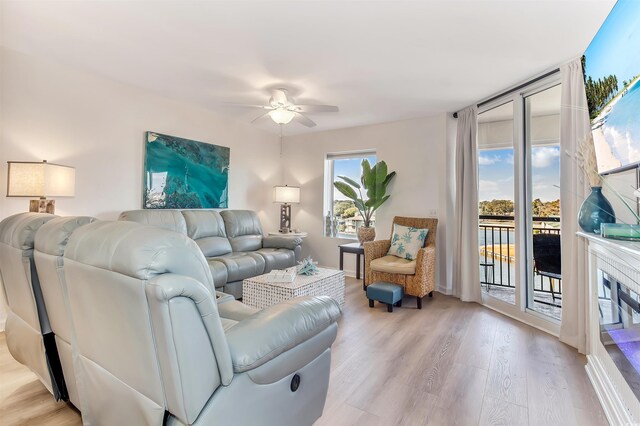 living room with a ceiling fan and light wood-type flooring