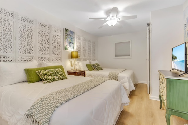 bedroom featuring a ceiling fan, baseboards, and light wood-type flooring