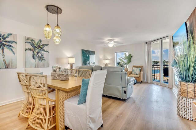 dining room with baseboards, ceiling fan, and light wood-type flooring