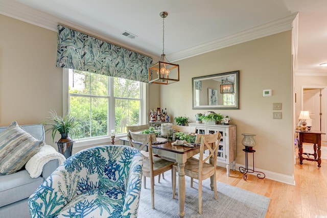 128 Puffin Dr Unit 1-E, Pawleys Island, SC 29585 - dining space with a chandelier, ornamental molding, and light wood finished floors