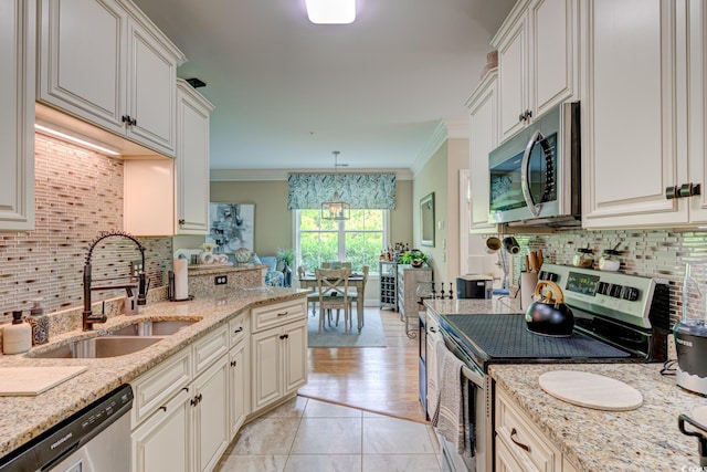 128 Puffin Dr Unit 1-E, Pawleys Island, SC 29585 - kitchen featuring stainless steel appliances, backsplash, ornamental molding, light stone counters, and light tile patterned floors