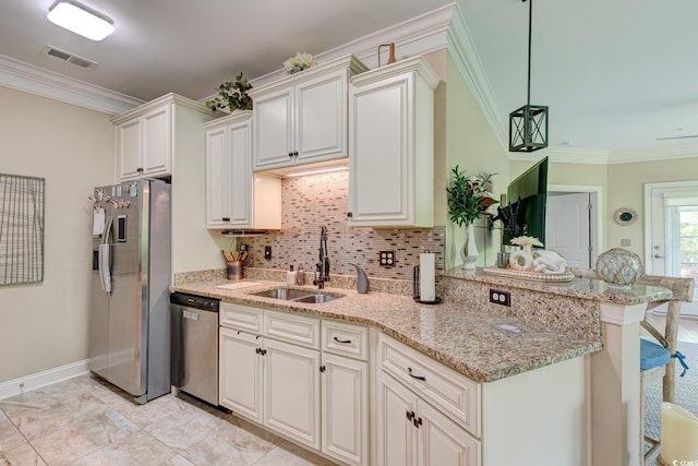 128 Puffin Dr Unit 1-E, Pawleys Island, SC 29585 - kitchen featuring stainless steel appliances, ornamental molding, decorative backsplash, a breakfast bar, and light stone countertops