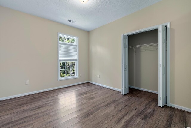 148 Scotch Broom Dr Unit 201, Little River, SC 29566 - unfurnished bedroom featuring wood finished floors, a closet, baseboards, and a textured ceiling