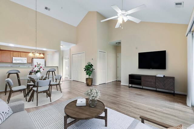 148 Scotch Broom Dr Unit 201, Little River, SC 29566 - living area featuring a chandelier, ceiling fan, light wood-style floors, high vaulted ceiling, and baseboards
