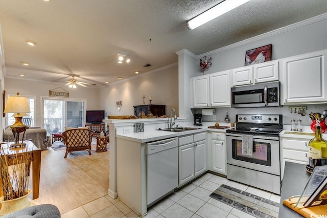 kitchen featuring stainless steel appliances, a sink, a peninsula, open floor plan, and a ceiling fan